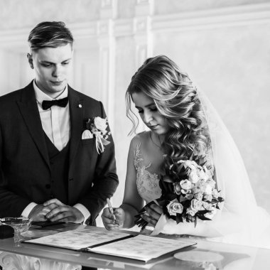 siyah beyaz fotoğraf. Gelin ve damat evlilik sözleşmesini imzalıyorlar..