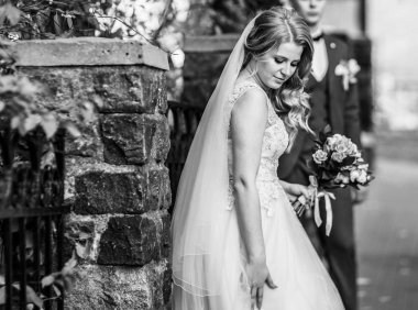 Gelin ve damat büyük bir şehrin sokaklarında. siyah beyaz fotoğraf