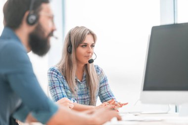 Kapat. Masada oturan kulaklıklı bir grup çalışan.