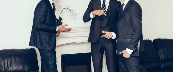 Three businessmen discussing a deal, standing in the meeting room — Stock Photo, Image