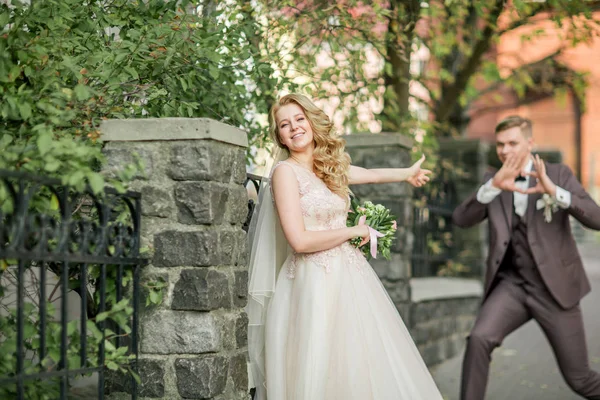 Счастливая невеста и жених делают фотосессию на улице города — стоковое фото