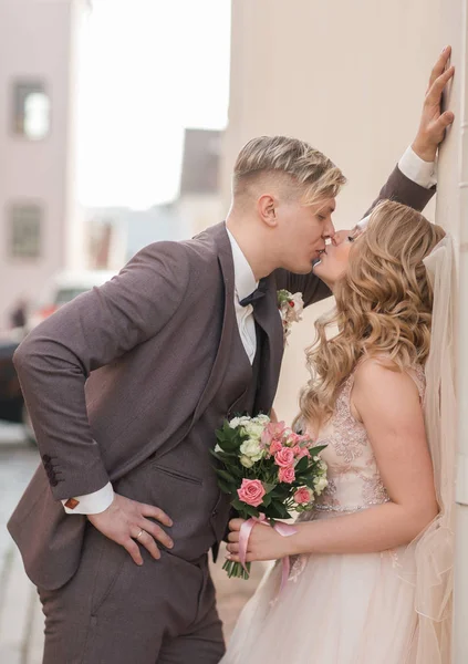 Novia y novio están hablando de pie cerca del edificio de la ciudad. —  Fotos de Stock