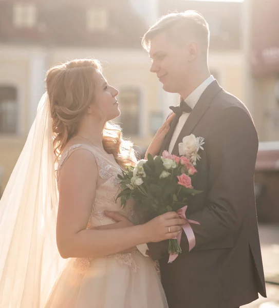 Bride and groom are talking standing near the city building. — Stock Photo, Image