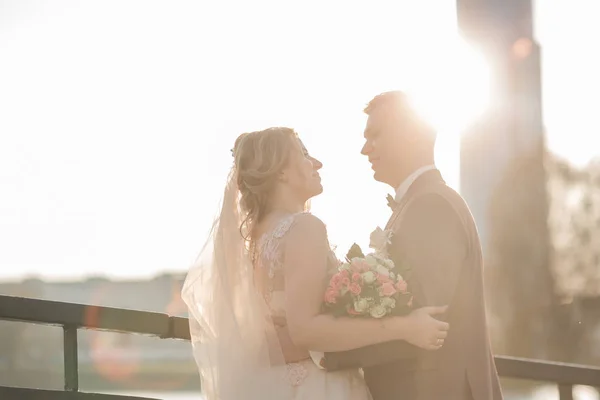 Couple heureux jeunes mariés debout sur le pont. — Photo