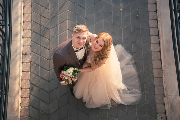 Vue de dessus. heureux marié et mariée debout sur le trottoir de pierre — Photo