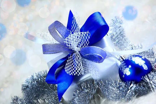 Weihnachtsgeschenk und blaue Kugeln auf weißem Hintergrund. — Stockfoto