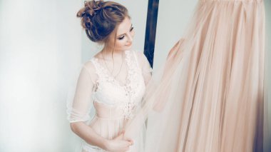 Mutlu kız gelinliğine bakıyor.