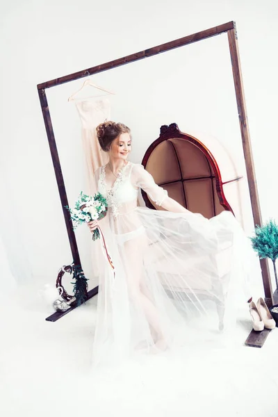 Bella sposa in un abito boudoir con un mazzo di fiori — Foto Stock