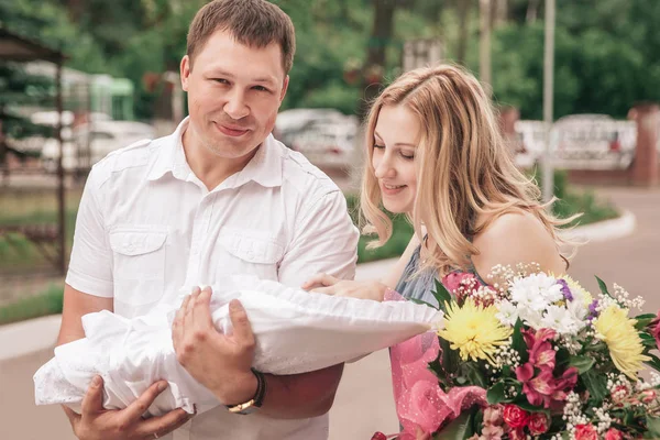 Fiatal szülők újszülött baba áll a város utcáján — Stock Fotó