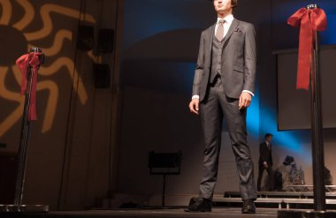 Moda gösterisi sırasında poz veren erkek manken.