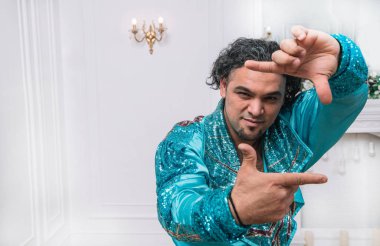 Kapatın. Çingene bir adam ellerindeki çerçeveyi gösteriyor.