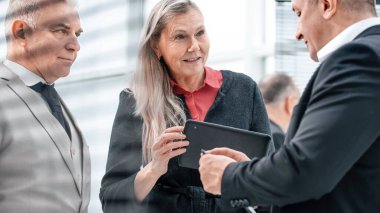bir grup iş adamı modern bir ofiste iş konularını tartışıyor.