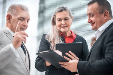 Proje Yöneticisi çalışma belgelerini meslektaşlarıyla tartışıyor