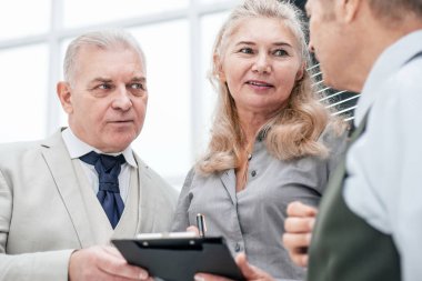 Kapat. Yeni bir iş planı üzerinde çalışan asistanlarla birlikte..