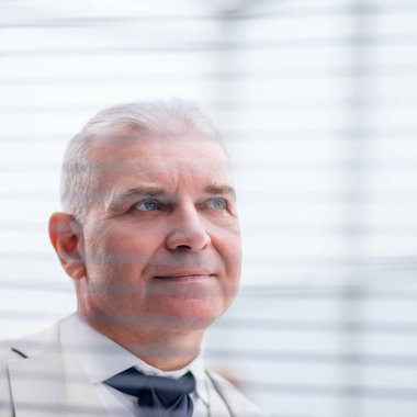 Kapat. Pencere perdelerinden bakan düşünceli iş adamı