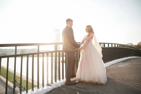 Lyckliga par nygifta stående på bron. — Stockfoto