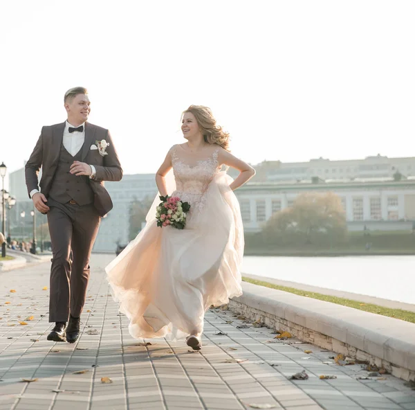 Visão traseira. feliz recém-casados andando por uma rua da cidade — Fotografia de Stock