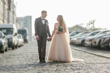 Mutlu gelin ve damat Şehir caddesinde yürüyor.