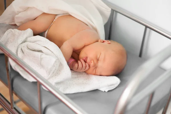 Pasgeboren baby slaapt zoet in een wieg. — Stockfoto