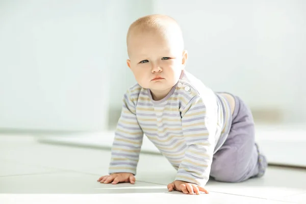 Närbild av en söt ettårig flicka krypa runt på golvet — Stockfoto