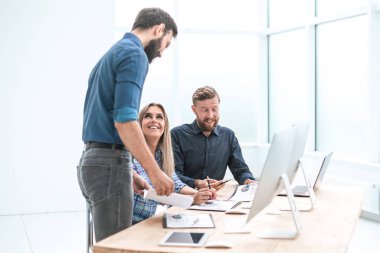 İş adamları çalışma belgelerini hafif bir ofiste tartışıyor..