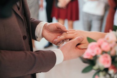 Kapat. Gelin ve damat alyanslarını değiş tokuş ediyorlar..