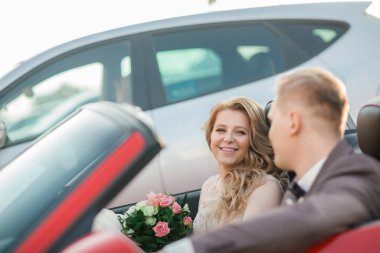 Mutlu gelin ve damat lüks bir arabada oturuyor..