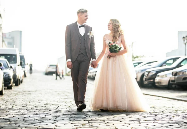 Ευτυχισμένη νύφη και γαμπρός περπατώντας στο δρόμο της πόλης. — Φωτογραφία Αρχείου