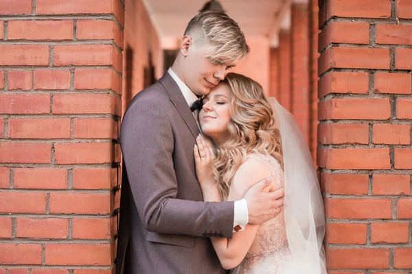 Lyckliga nygifta par kramar varandra medan de går — Stockfoto
