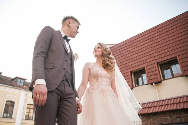 Bruid en bruidegom wandelen door de straat van de oude stad. — Stockfoto