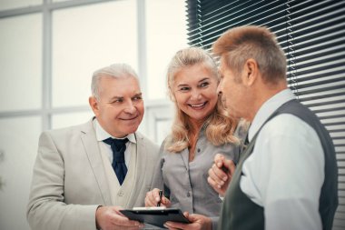 Kapat. gülümseyen çalışanlar bir iş belgesini tartışıyorlar .