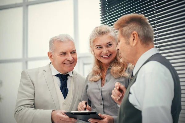 Kapat. gülümseyen çalışanlar bir iş belgesini tartışıyorlar .