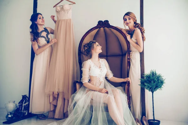 Kvinna försöker på bröllop klänning med kvinnliga vänner att ha kul och ta bilder. — Stockfoto