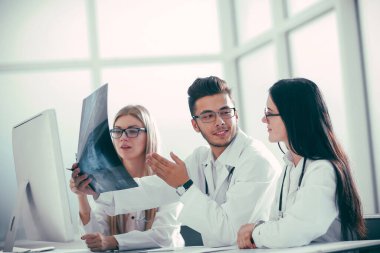 Bir grup doktor hastaların röntgenlerini tartışıyor.