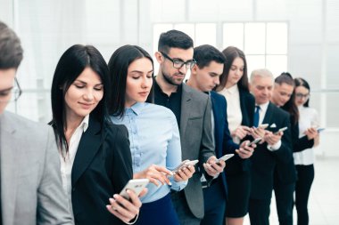 group of business people with smartphones standing in a row