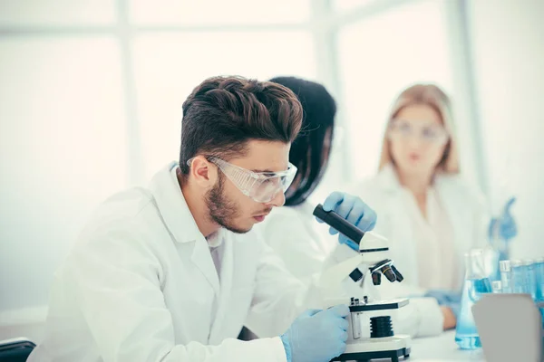 De cerca. un joven científico que estudia las características del coronavirus —  Fotos de Stock