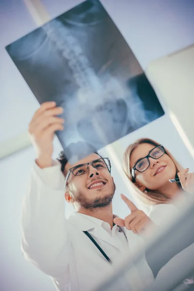 İki ortopedik doktor hastanın röntgenine bakıyor. — Stok fotoğraf