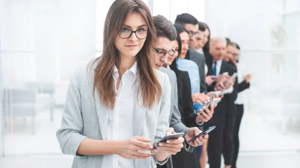 Grupo de pessoas de negócios com smartphones em pé em uma linha — Fotografia de Stock