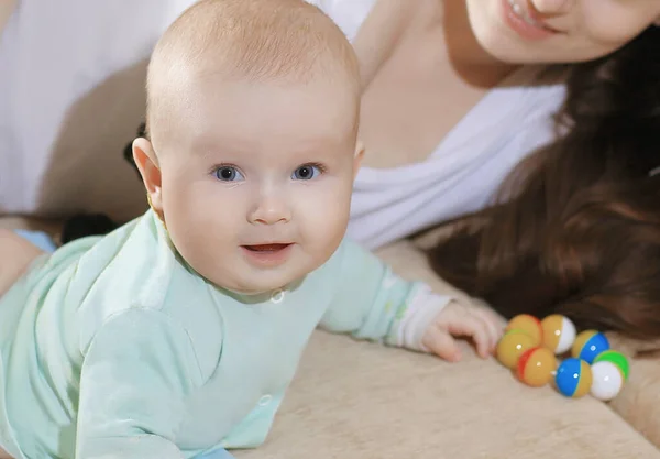 Close up.mom and baby lying on the couch and looking at the came — Stock Photo, Image