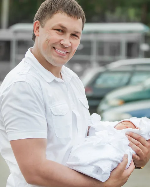 Apa az újszülött gyerekével az autója mellett áll. — Stock Fotó