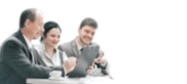 Equipe de negócios discutindo um papel de trabalho na mesa de café. em um borrão, com uma cópia do espaço — Fotografia de Stock