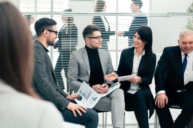 İş arkadaşları konferans odasında mali verileri tartışıyor