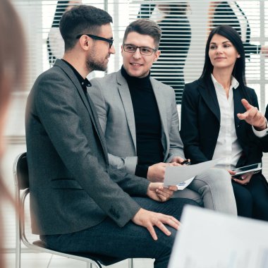 Patron çalışma grubuyla iş meselelerini tartışıyor.