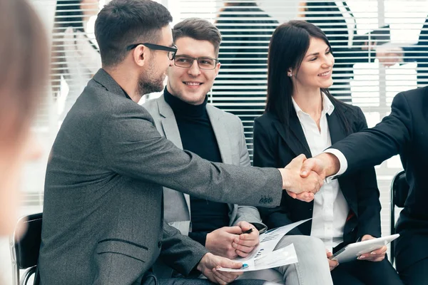 Jefe estrechando la mano con un empleado durante una reunión de trabajo — Foto de Stock