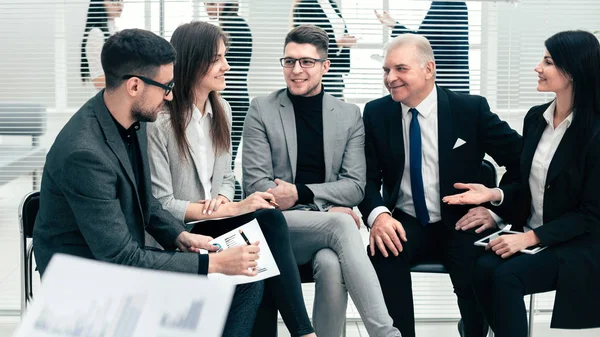 Grupo de trabajo discute sus ideas sentado en la sala de conferencias — Foto de Stock