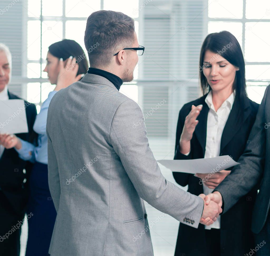 business people greet each other with a handshake in the office