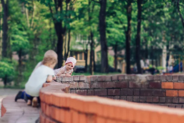 Jonge gezinnen met kinderen die op een zomerdag bij de fontein rusten — Stockfoto