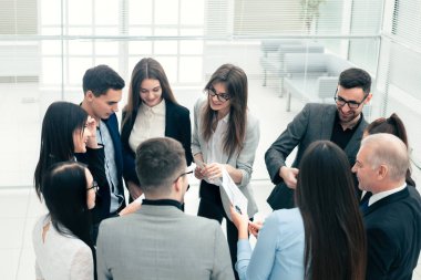 boss and a group of employees discussing business documents.
