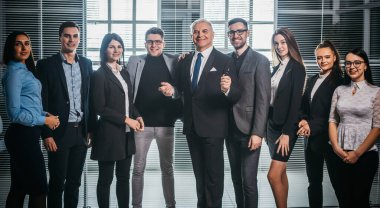 Bir grup mutlu iş adamı ofis lobisinde duruyor.