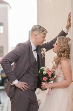 Gelin ve damat şehir binasının yanında konuşuyorlar..